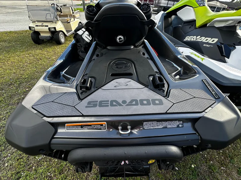 Slide: The Image of 2023 Sea-Doo RXP-X 300 jet ski, rear view, parked on grass. - 3