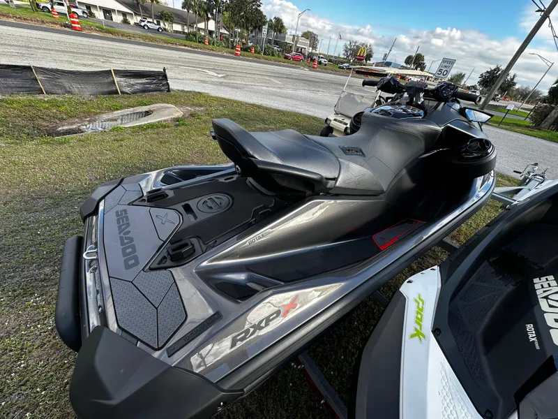 Slide: The Image of 2023 Sea-Doo RXP-X 300 jet ski parked on grass near a road. - 4