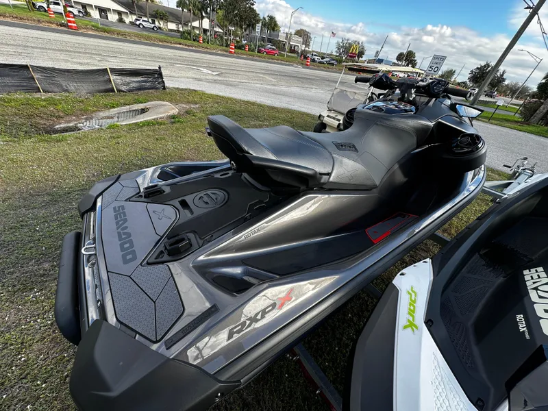 Slide: The Image of 2023 Sea-Doo RXP-X 300 jet ski parked on grass near a road. - 5