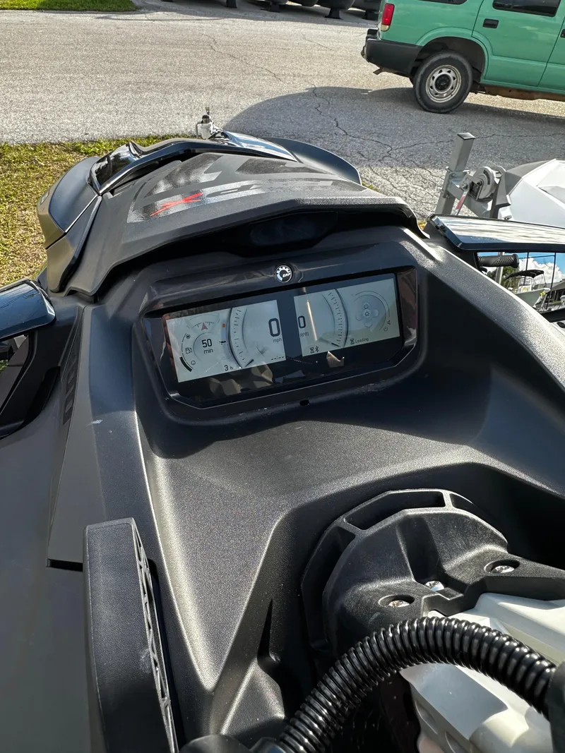 Slide: The Image of 2023 Sea-Doo RXP-X 300 dashboard with digital display, parked outdoors. - 7