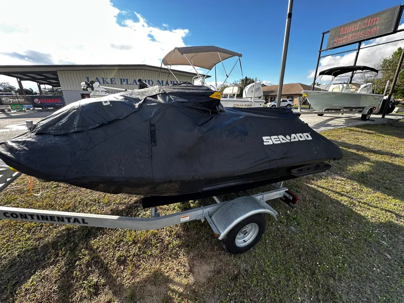 Slide: The Image of 2023 Sea-Doo RXP-X 300 jet ski covered on a trailer, parked outdoors. - 9