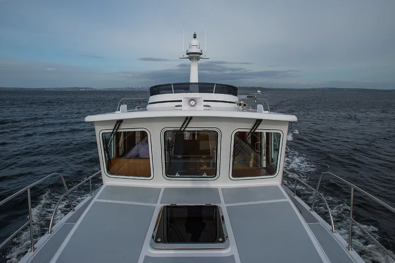Slide: The Image of Helmsman Trawlers 38E Pilothouse 2026 cruising on open water. - 12