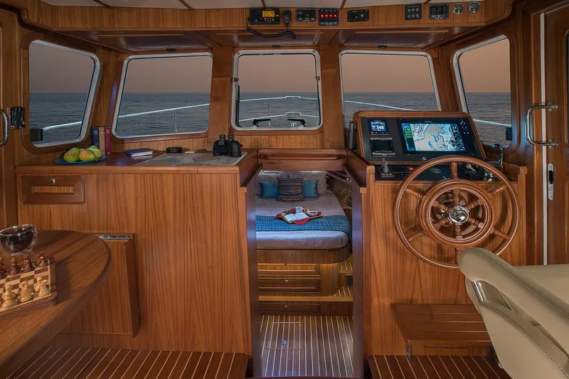 Slide: The Image of 2026 Helmsman Trawlers 38E Pilothouse interior with navigation equipment and cozy cabin. - 27