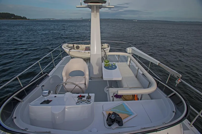 Slide: The Image of Helmsman Trawlers 38E Pilothouse 2026 yacht deck with seating and ocean view. - 8