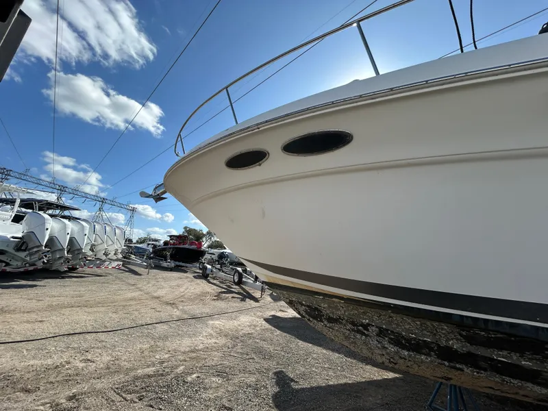 Slide: The Image of 2002 Sea Ray 340 Sundancer boat on dry dock under a clear blue sky. - 11