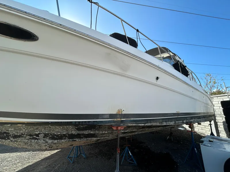 Slide: The Image of 2002 Sea Ray 340 Sundancer yacht on stands, side view, clear sky background. - 12