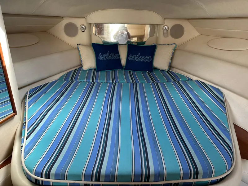Slide: The Image of 2002 Sea Ray 340 Sundancer cabin with striped bedding and decorative pillows. - 19