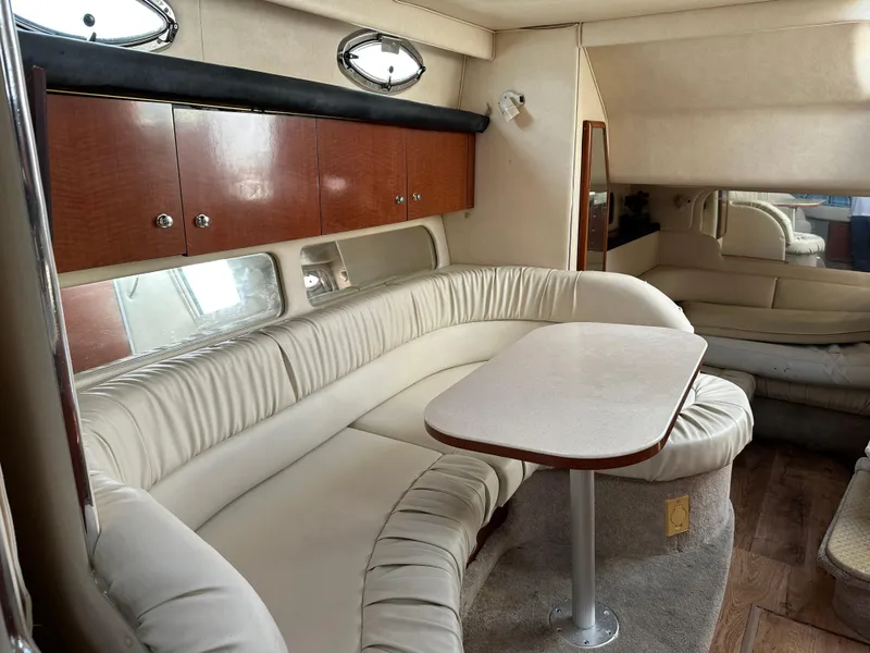 Slide: The Image of 2002 Sea Ray 340 Sundancer interior with cream seating and wooden cabinets. - 23