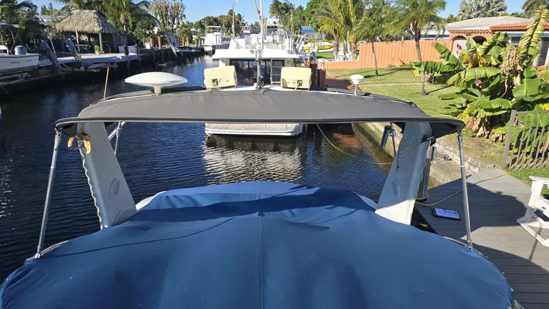Slide: The Image of 2002 Sea Ray 340 Sundancer docked in a scenic canal setting. - 25