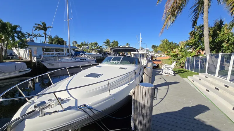 Slide: The Image of 2002 Sea Ray 340 Sundancer docked, surrounded by palm trees and clear blue sky. - 27