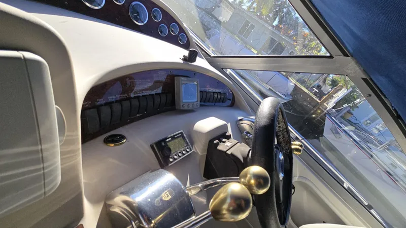 Slide: The Image of 2002 Sea Ray 340 Sundancer helm with steering wheel and control panel. - 7