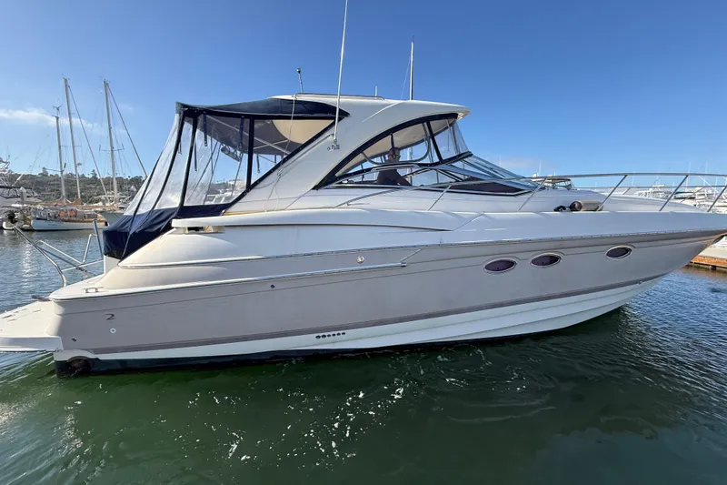 Slide: The Image of 2003 Regal Commodore 4260 yacht docked in a marina under clear blue skies. - 31