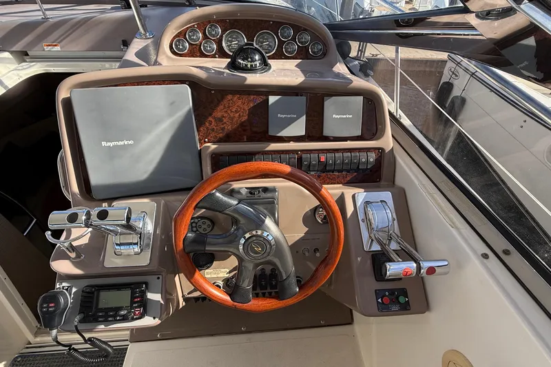 Slide: The Image of 2003 Regal Commodore 4260 helm with Raymarine navigation and wooden steering wheel. - 34
