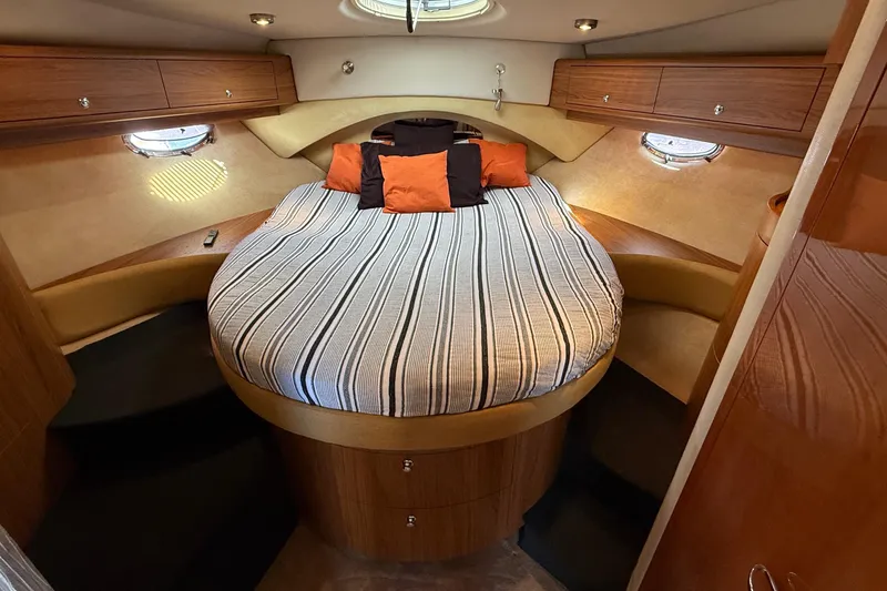 Slide: The Image of Luxurious cabin interior of 2003 Regal Commodore 4260 yacht with cozy bed and wood accents. - 42