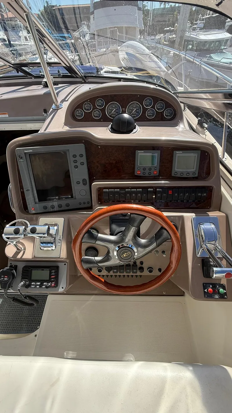 Slide: The Image of 2003 Regal Commodore 4260 boat dashboard with steering wheel and navigation instruments. - 9