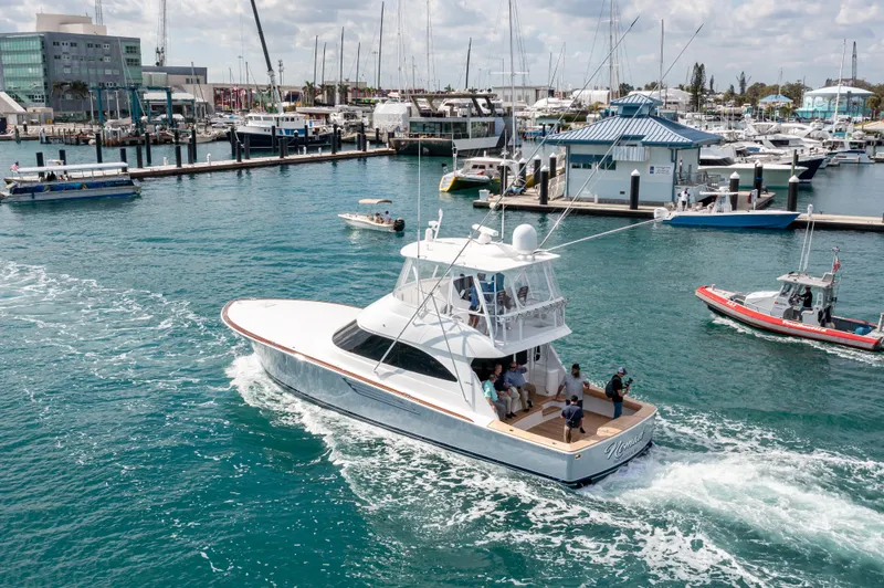 The Image of 2024 Viking 54 Convertible yacht cruising in a busy marina. - 1