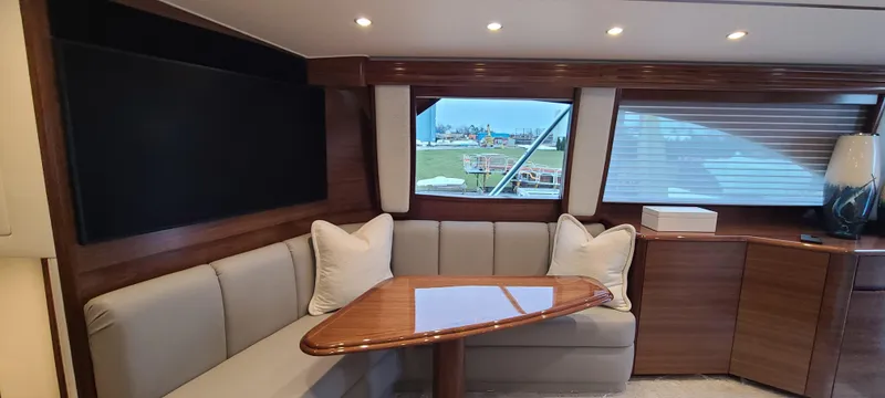 Slide: The Image of 2024 Viking 54 Convertible yacht interior with elegant seating and wooden table. - 3