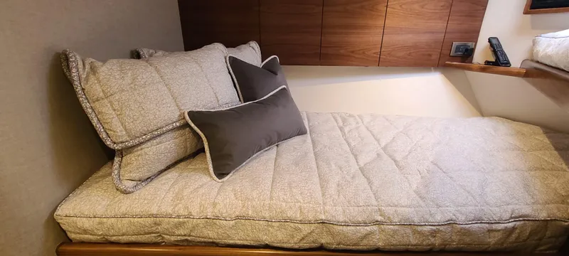 Slide: The Image of 2024 Viking 54 Convertible interior with cozy bed and pillows. - 5