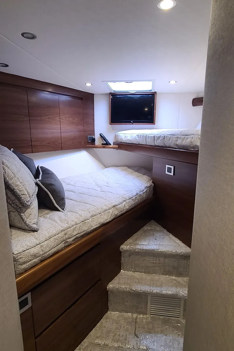 Slide: The Image of 2024 Viking 54 Convertible yacht cabin with cozy beds and modern design. - 9