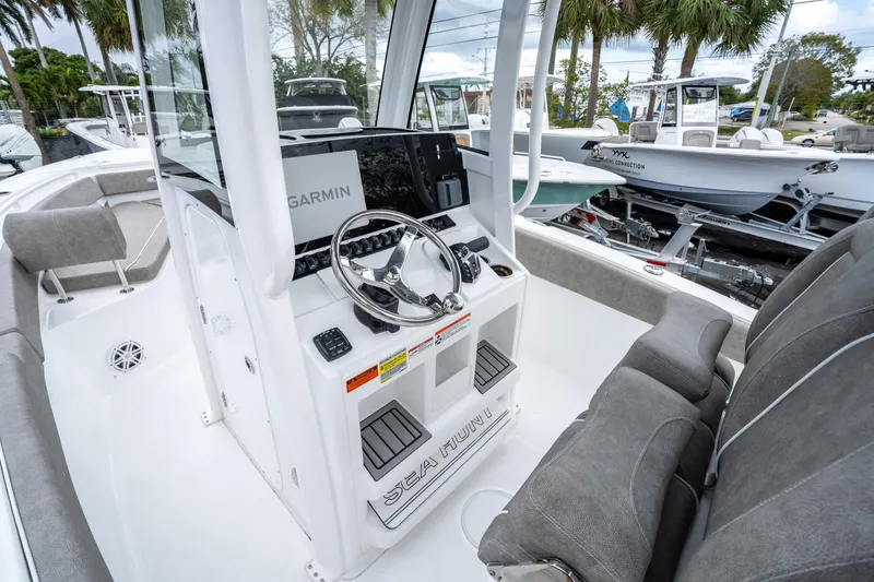Slide: The Image of 2025 Sea Hunt Ultra 245 SE boat interior with Garmin navigation system and plush seating. - 24