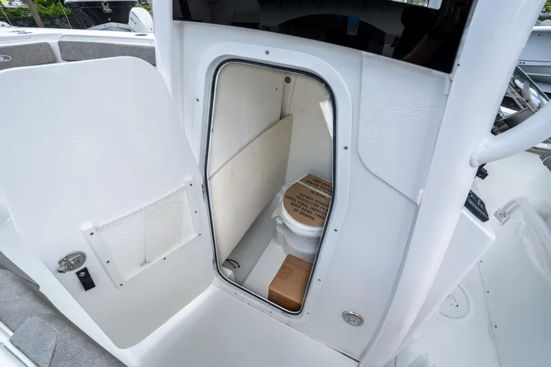 Slide: The Image of Sea Hunt Ultra 245 SE 2025 boat interior with compact marine toilet. - 29