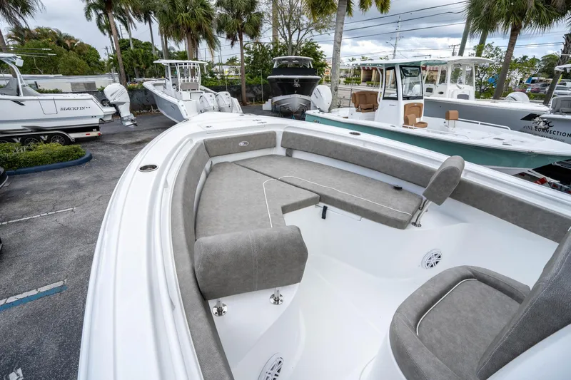 Slide: The Image of 2025 Sea Hunt Ultra 245 SE boat with spacious seating, docked among other boats. - 30
