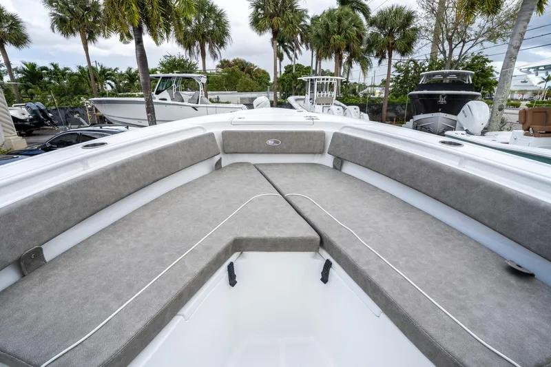 Slide: The Image of 2025 Sea Hunt Ultra 245 SE boat interior with cushioned seating and palm trees in the background. - 32
