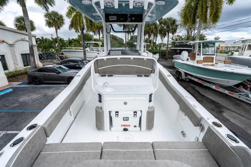 Slide: The Image of 2025 Sea Hunt Ultra 245 SE boat interior with seating and console, parked outdoors. - 9