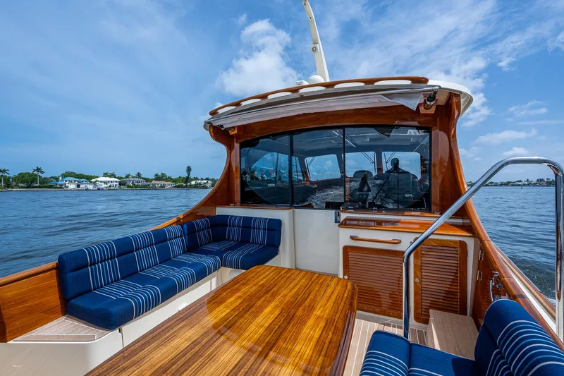 Slide: The Image of 2021 Hinckley Talaria 43 Motoryacht with elegant wood finish and blue seating on open water. - 29
