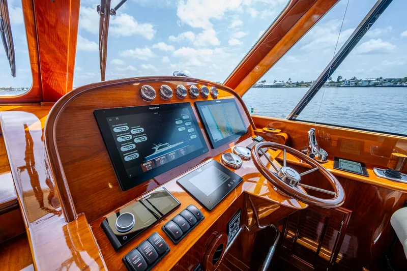 Slide: The Image of 2021 Hinckley Talaria 43 Motoryacht helm with modern navigation displays and wooden finish. - 3