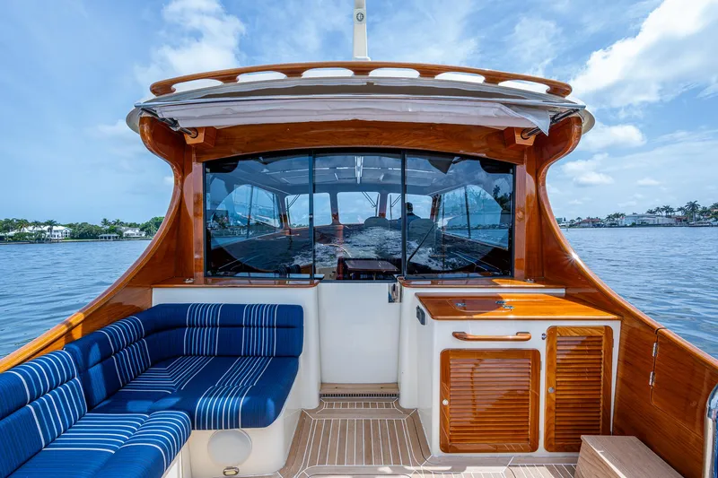 Slide: The Image of 2021 Hinckley Talaria 43 Motoryacht interior with blue seating and wooden cabinetry on a sunny day. - 30