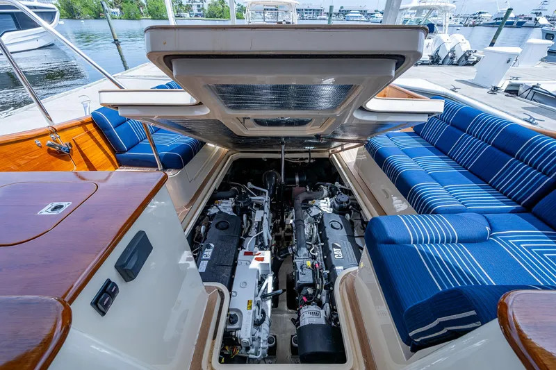 Slide: The Image of 2021 Hinckley Talaria 43 Motoryacht engine compartment with blue-striped seating and wooden accents. - 37