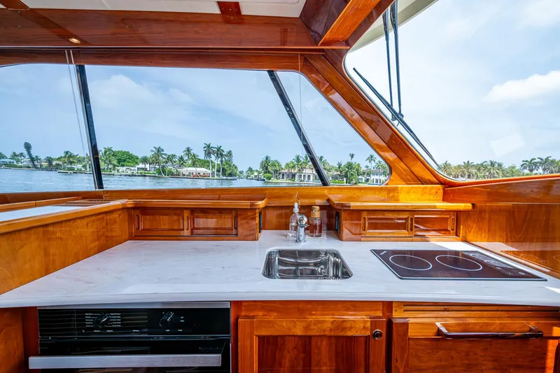 Slide: The Image of Luxurious 2021 Hinckley Talaria 43 Motoryacht kitchen with sleek wood finish and modern appliances. - 8