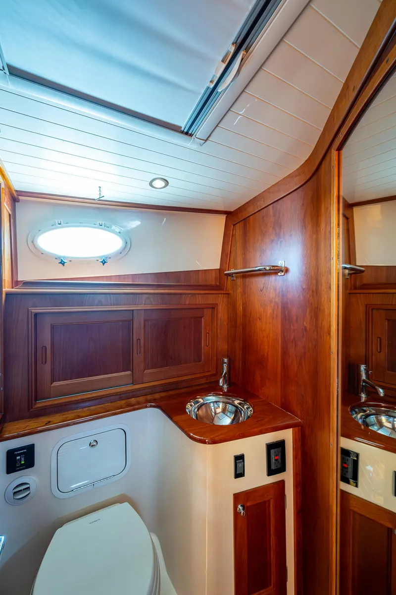 Slide: The Image of Hinckley Talaria 43 Motoryacht 2021 bathroom with wood cabinetry and stainless steel sink. - 25