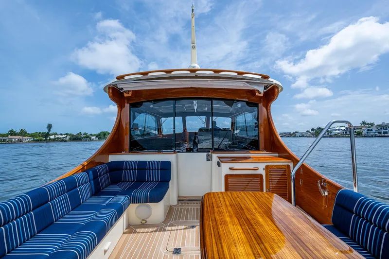 Slide: The Image of 2021 Hinckley Talaria 43 Motoryacht with elegant wood finish and blue seating on open water. - 28