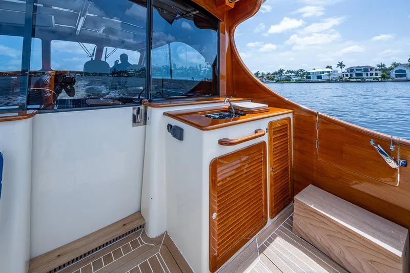 Slide: The Image of Hinckley Talaria 43 Motoryacht 2021 interior with wooden cabinetry and waterfront view. - 32