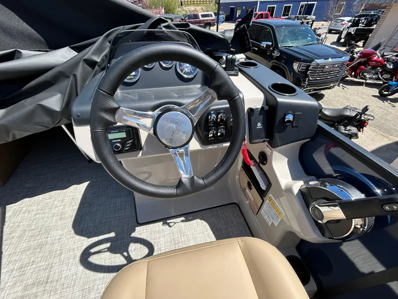 Slide: The Image of 2025 Lowe LS210WT boat interior with beige seating and steering console. - 2