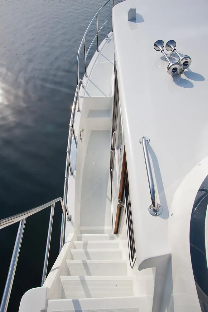 Slide: The Image of Helmsman Trawlers 43E Pilothouse 2026 yacht deck with stairs and railing. - 13