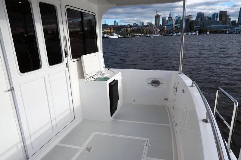Slide: The Image of 2026 Helmsman Trawlers 43E Pilothouse deck with city skyline view. - 15
