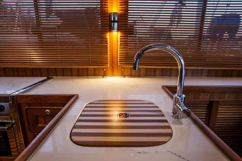 Slide: The Image of Luxurious kitchen sink area on 2026 Helmsman Trawlers 43E PILOTHOUSE with elegant wood accents. - 23