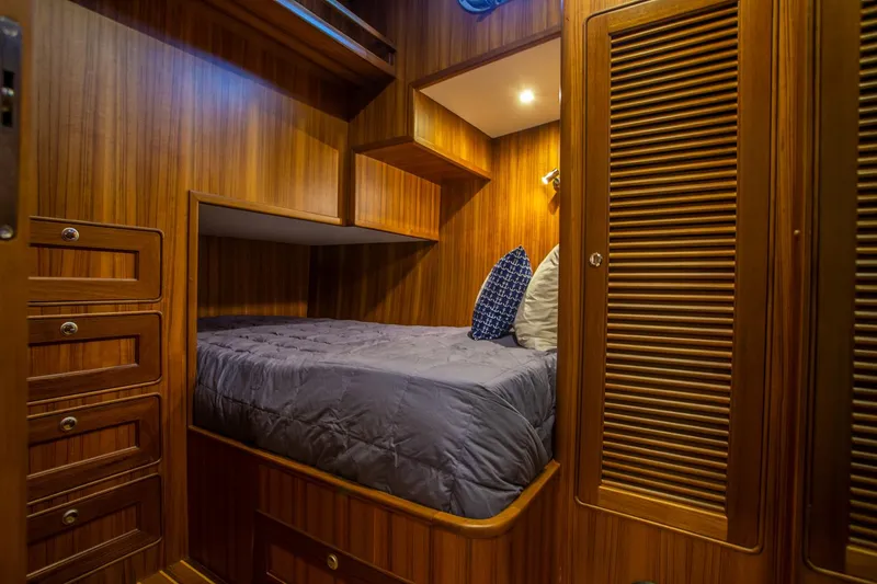 Slide: The Image of Cozy cabin interior of 2026 Helmsman Trawlers 43E PILOTHOUSE with wood paneling and bed. - 34