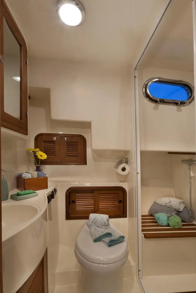 Slide: The Image of 2026 Helmsman Trawlers 43E PILOTHOUSE bathroom with modern fixtures and wooden accents. - 37