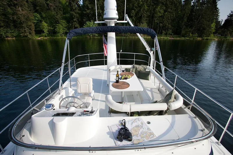 Slide: The Image of Helmsman Trawlers 43E Pilothouse 2026 on serene water, featuring a spacious deck with seating. - 9