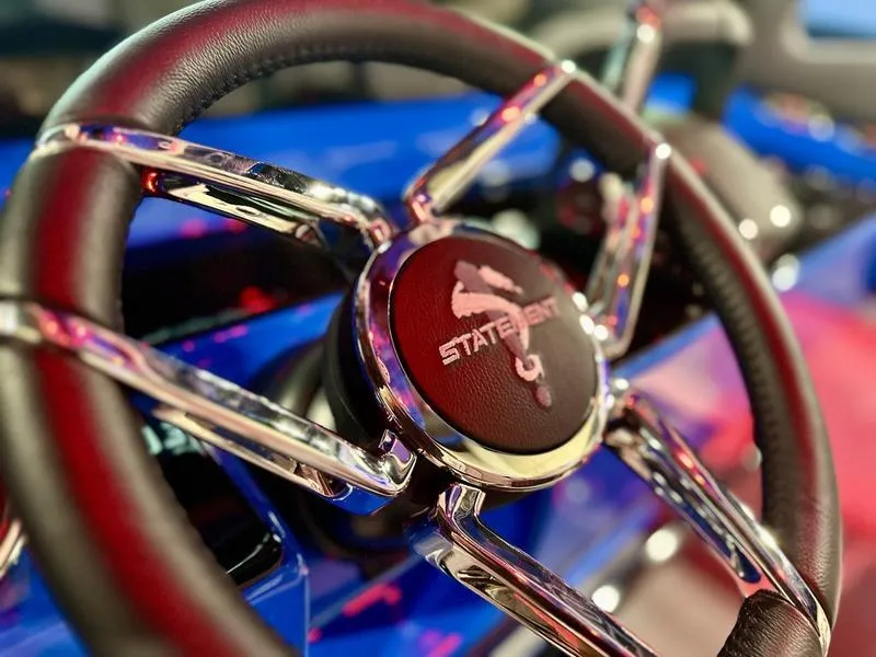 Slide: The Image of Steering wheel of 2025 Statement 350 Open Center Console boat, featuring sleek chrome details. - 6