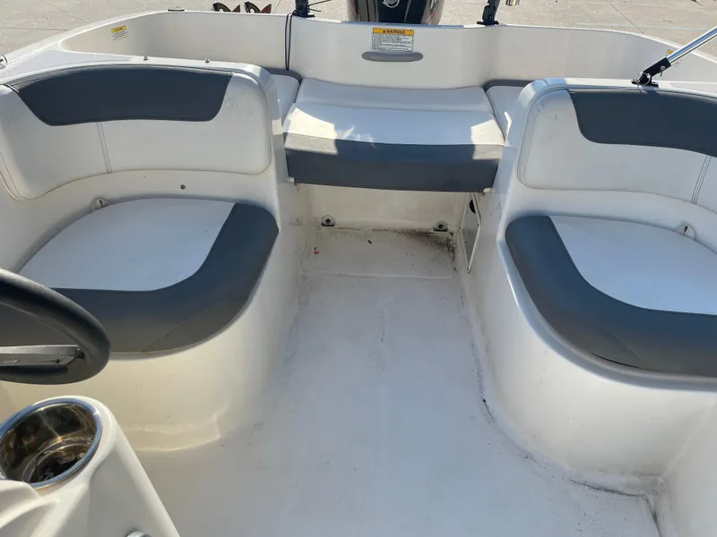Slide: The Image of 2017 Bayliner Element E16 boat interior with gray and white seating arrangement. - 12