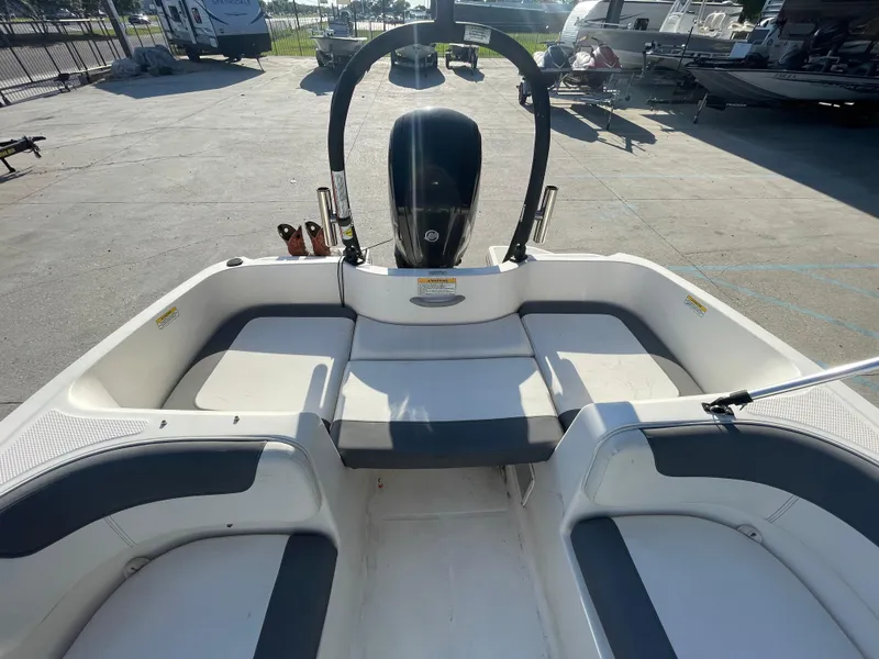 Slide: The Image of 2017 Bayliner Element E16 boat interior with seating and motor in a marina setting. - 13