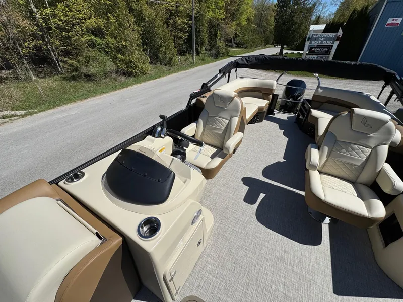 Slide: The Image of 2025 Lowe SS250WT pontoon boat with Mercury outboard motor on grassy area. - 4