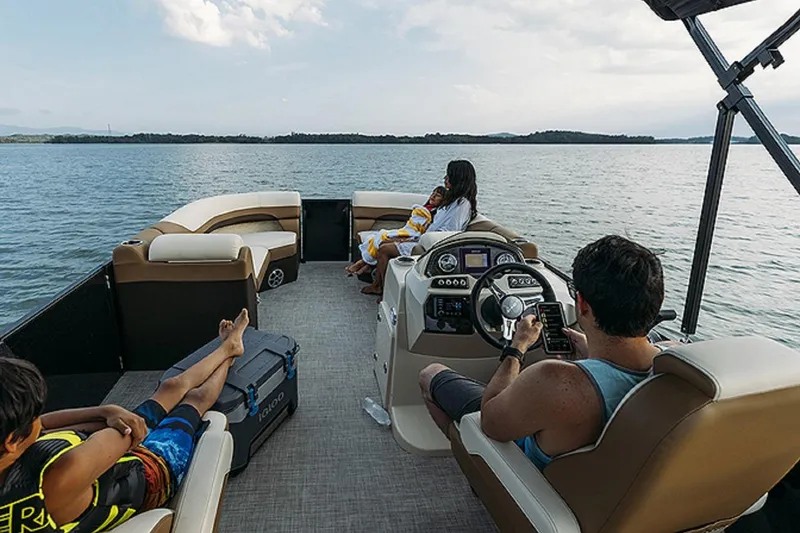 Slide: The Image of 2025 Lowe SS250WT pontoon boat on a lake with passengers relaxing and enjoying the view. - 9