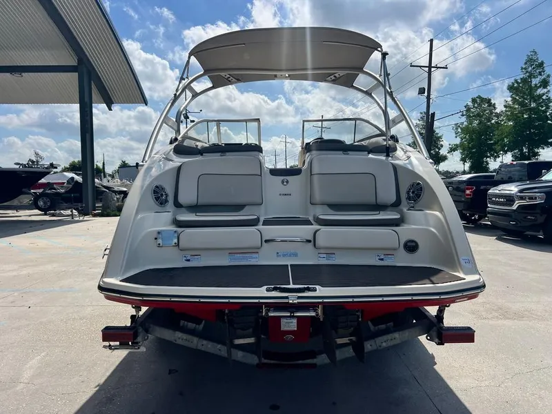 Slide: The Image of 2014 Yamaha Boats 242 Limited S, rear view, parked outdoors under a cloudy sky. - 9