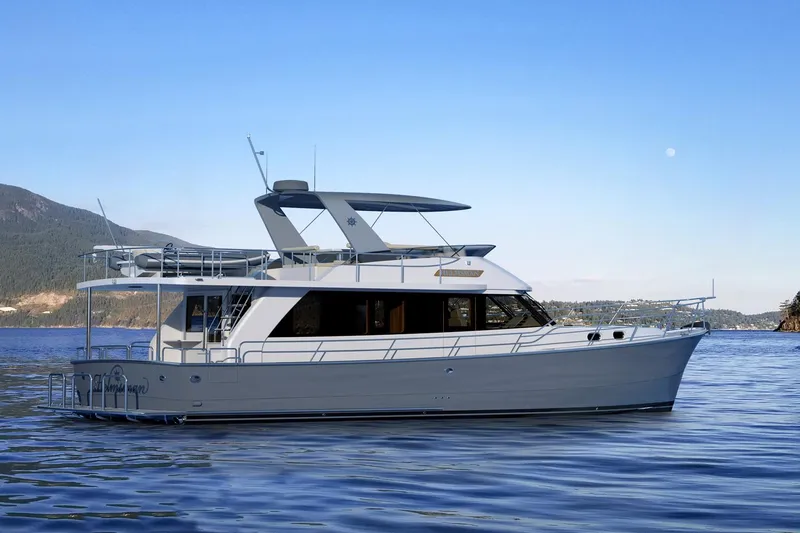 Slide: The Image of 2026 Helmsman Trawlers 43 Sedan yacht on calm water, scenic mountain backdrop. - 5